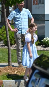 Ava Steensma, 7, traveled from Sidney NY, watched the parade with her mother, Natalie (not pictured) and her uncle, Justin Steensma (back). during Saturday's Oz-Stravaganza parade in Chittenango. Photo by Brian McDowell
